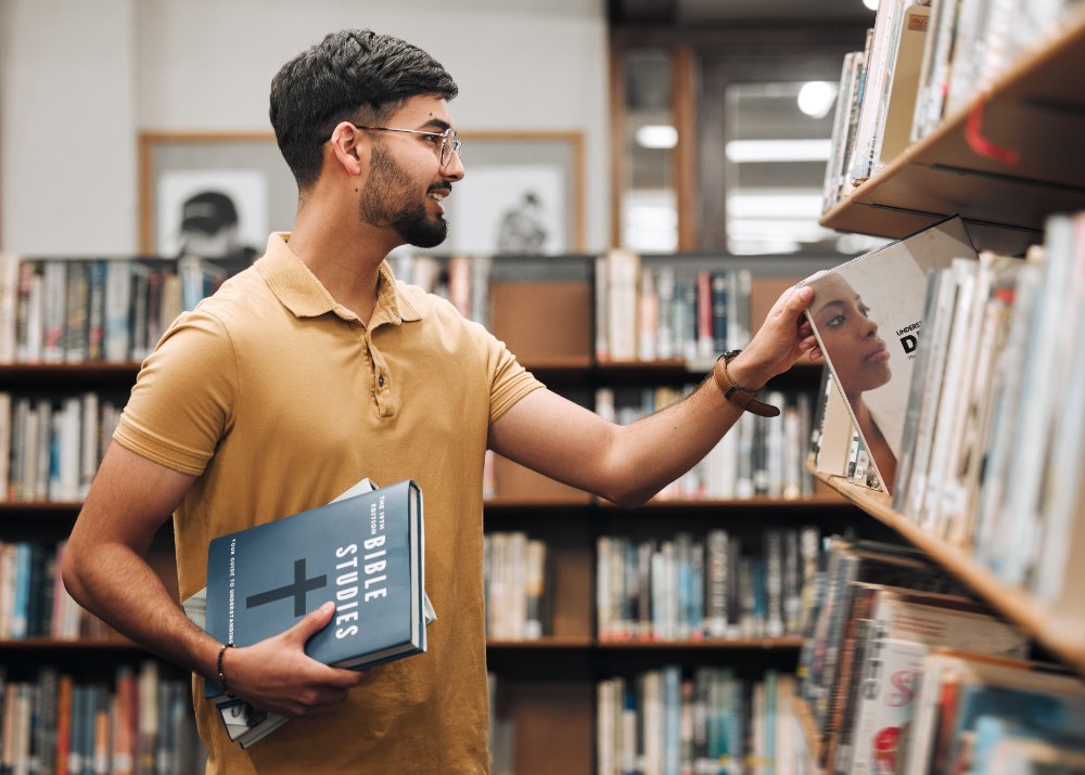 university-student-or-man-with-bible-in-a-library-2025-04-06-02-27-08-utc.jpg